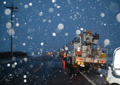 Utility vehicles driving through a storm