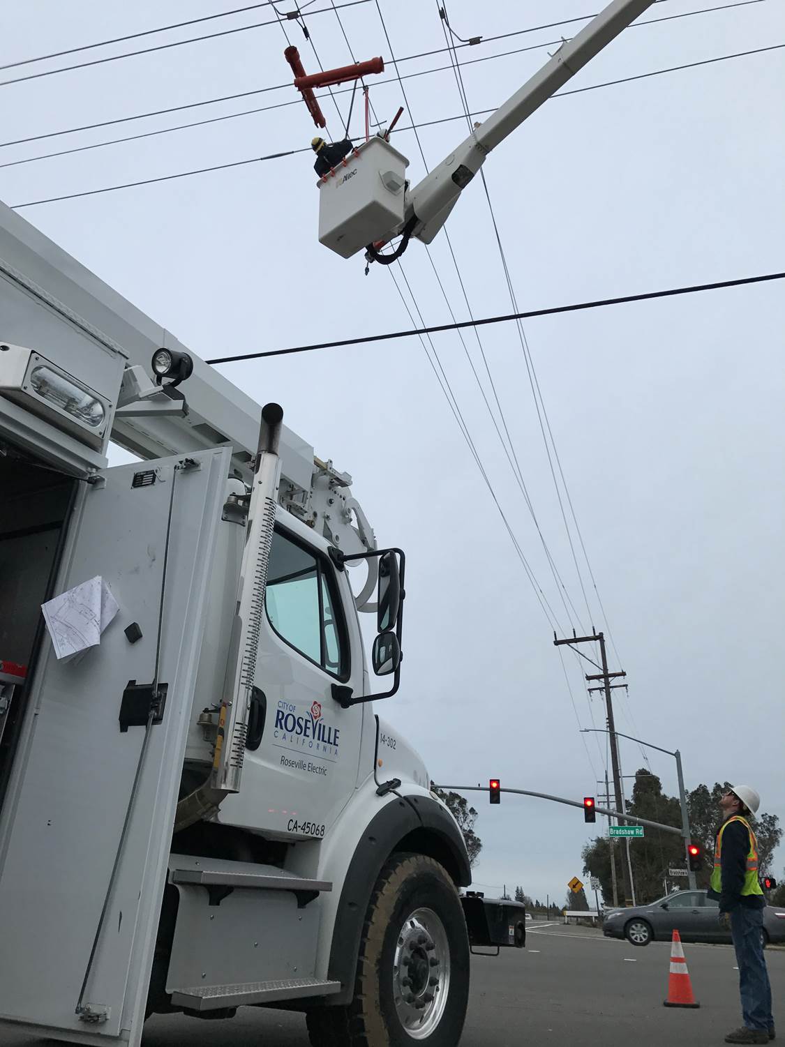 Man on crane fixing telephone wires